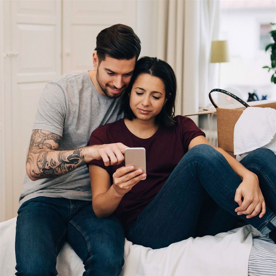 Mann og kvinne ser på en mobiltelefon