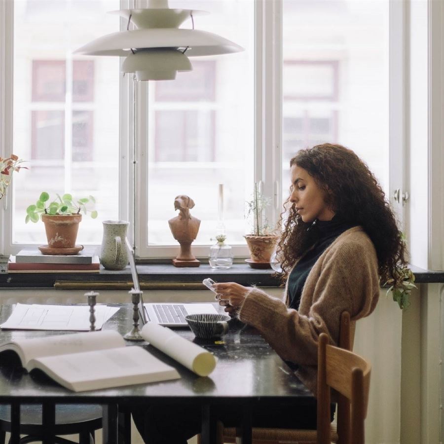 Mann sitter ved en datamaskin og tenker